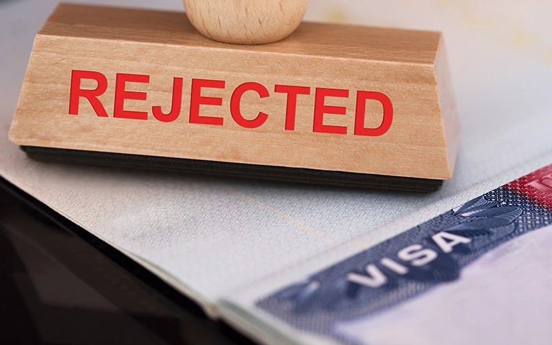 Close-up of a rejected stamp on a visa document
